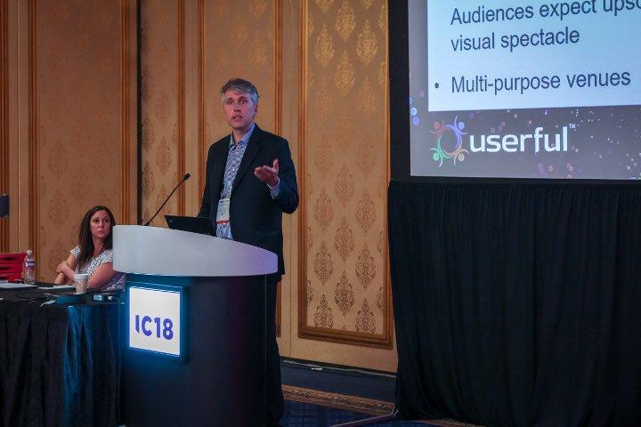 Tim Griffin, CTO di Userful, tiene una presentazione sull'AV-over-IP a Infocomm 2018, con Marielle Crisanti di Matrix Video Communications sullo sfondo.