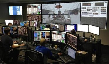Una sala di controllo con gli operatori alle loro postazioni di lavoro e una parete video che visualizza le riprese e i dati in tempo reale