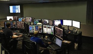Una sala di controllo con gli operatori alle loro postazioni di lavoro