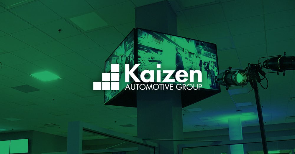 Video wall che mostra la pubblicità di un'auto in una concessionaria di proprietà di Kaizen Automotive Group con sovrapposizione verde e logo