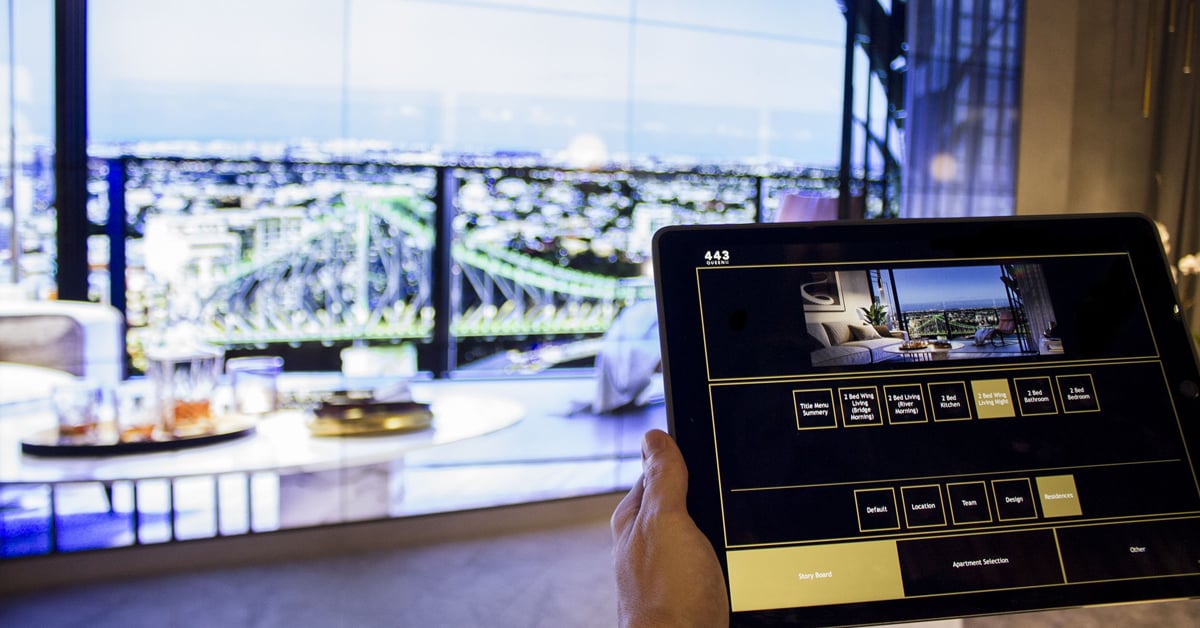 Ufficio vendite di Q1 Design in Australia, con un videowall che mostra le foto degli immobili, selezionate su un'interfaccia tablet