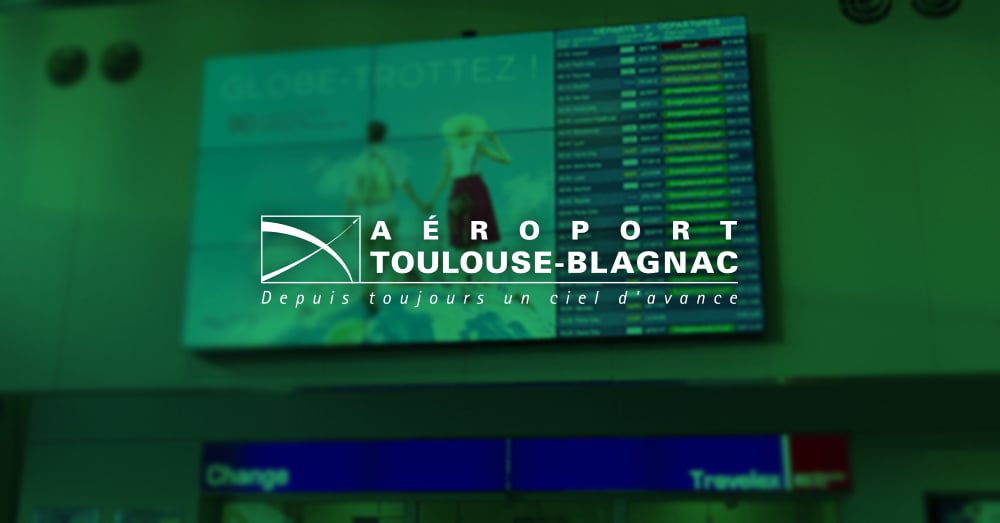 Video wall nell'aeroporto di Tolosa-Blagnac per la visualizzazione degli annunci e degli orari di partenza dei voli con sovrapposizione verde e logo