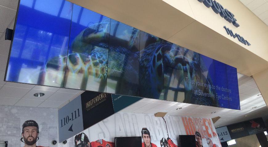 Videowall appeso in un centro commerciale che mostra una pubblicità del Silverstein Eye Centers