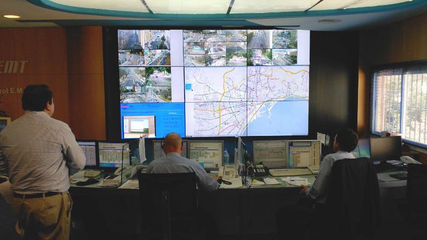 Centro di controllo EMT con operatori che monitorano le condizioni di transito attraverso le loro postazioni di lavoro e un video wall che visualizza i percorsi di transito, le riprese in diretta e i dati.