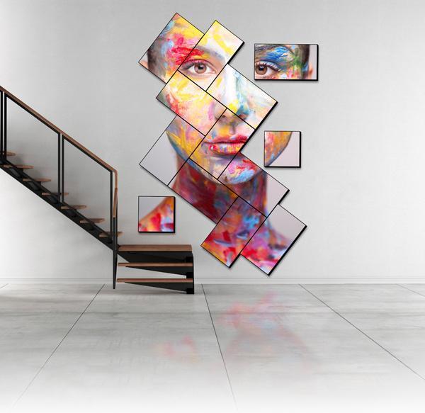 Una scala moderna e una parete video a mosaico artistico che mostra un'opera d'arte raffigurante un volto dipinto.
