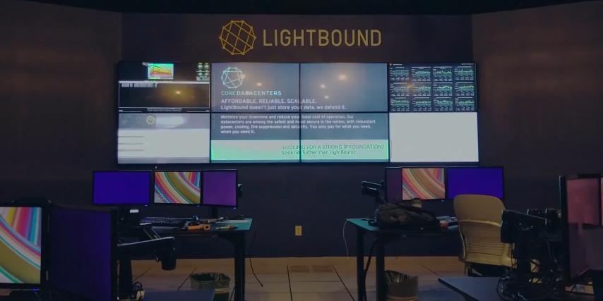 Sala di controllo Lightbound vuota con 2 postazioni di lavoro e videowall per la visualizzazione di siti web, dati e pubblicità.
