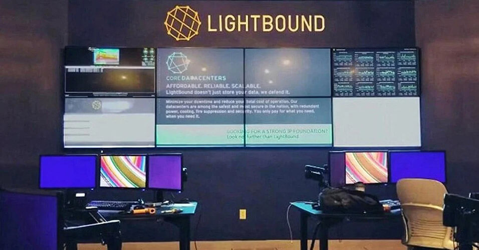 Sala di controllo Lightbound vuota con 2 postazioni di lavoro e videowall per la visualizzazione di siti web, dati e pubblicità.